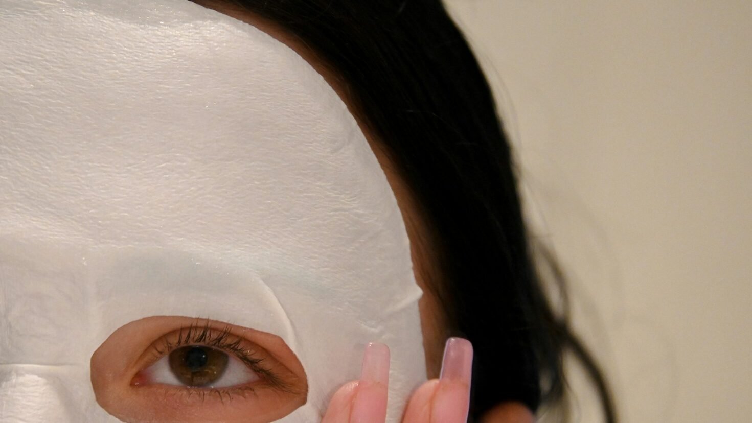 a woman with a white sheet mask product