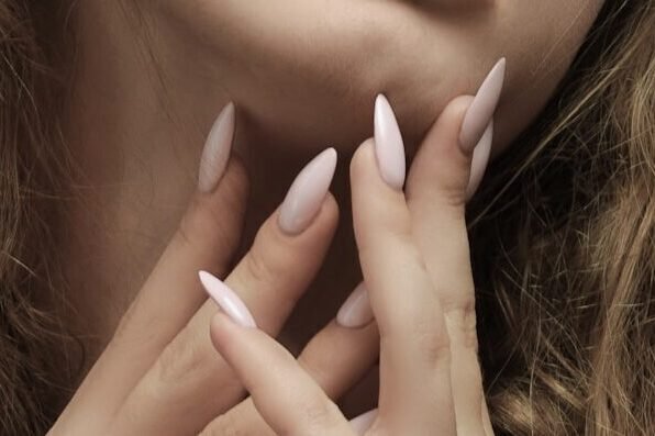 a woman with a pink almond shape nail 